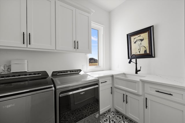 clothes washing area featuring sink, light tile patterned floors, cabinets, and washing machine and clothes dryer