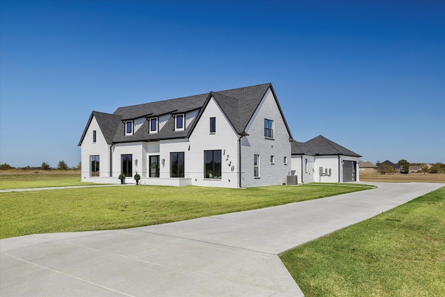 view of front of property with cooling unit, a front yard, and a garage