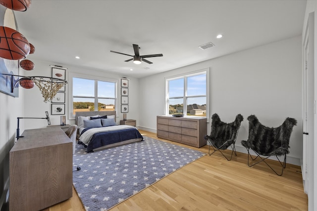 bedroom with multiple windows, ceiling fan, and light hardwood / wood-style flooring