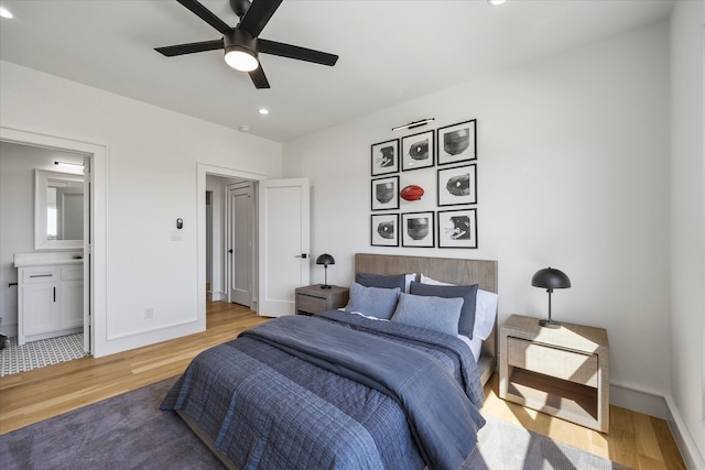 bedroom featuring hardwood / wood-style floors, ensuite bath, and ceiling fan