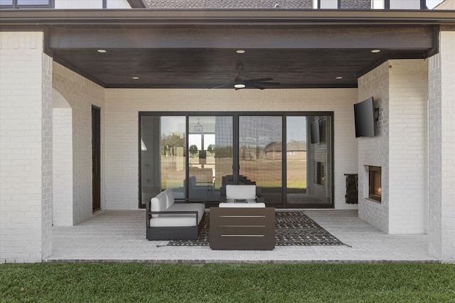 view of patio with an outdoor living space with a fireplace and ceiling fan