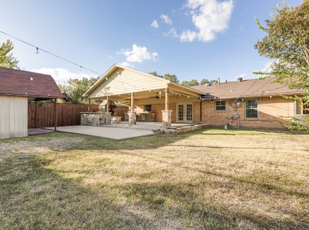 back of house featuring a patio area, a lawn, and ceiling fan