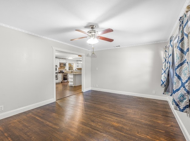 unfurnished room with ornamental molding, dark wood-type flooring, and ceiling fan