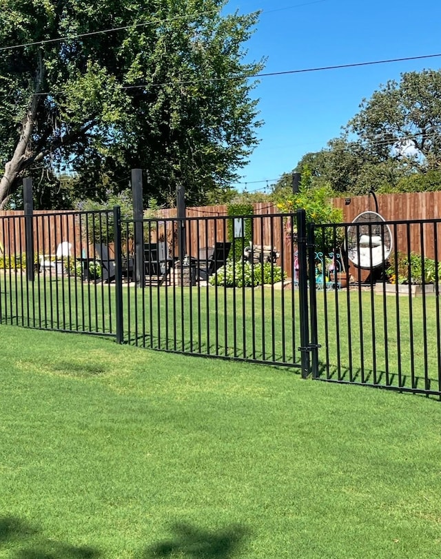 view of gate with a lawn