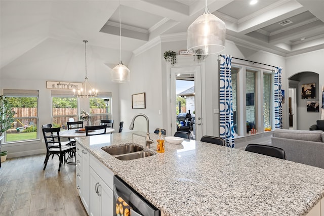 kitchen featuring white cabinetry, sink, hanging light fixtures, and dishwasher