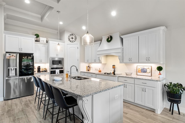 kitchen with appliances with stainless steel finishes, sink, a center island with sink, and white cabinets