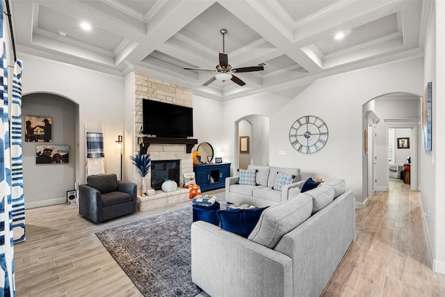 living room with crown molding, a fireplace, and light hardwood / wood-style floors