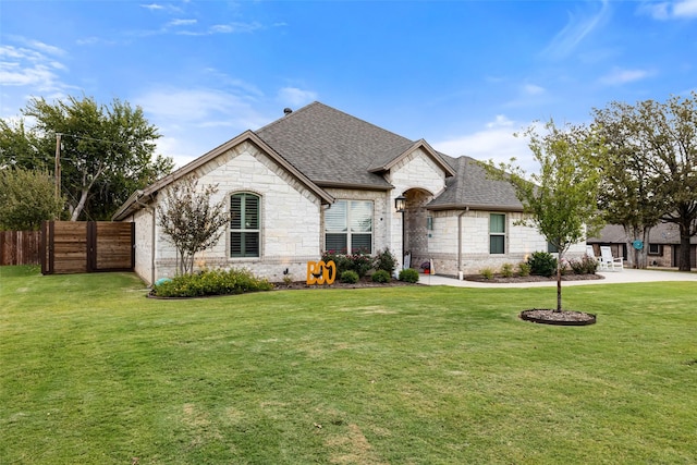 french country inspired facade featuring a front yard