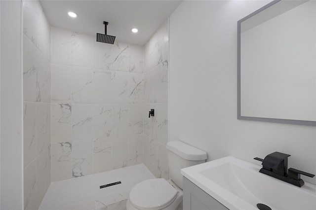 bathroom featuring tiled shower, vanity, and toilet