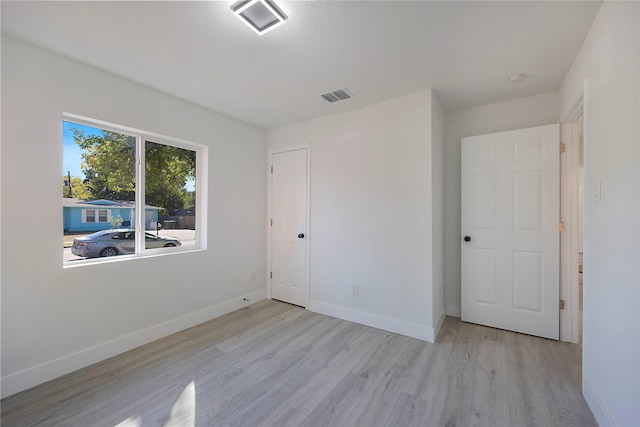 unfurnished bedroom with light hardwood / wood-style floors and a closet