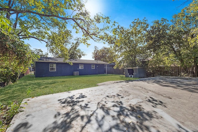 view of yard with a patio area, central AC unit, and a storage shed