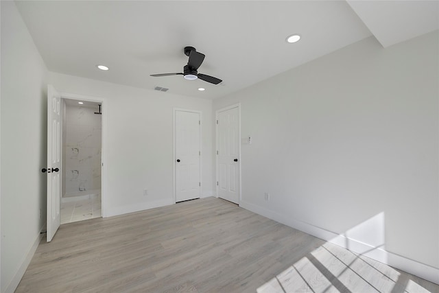 unfurnished bedroom featuring ensuite bath, ceiling fan, and light hardwood / wood-style flooring