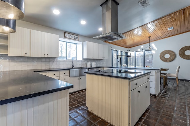 kitchen featuring a kitchen island, island exhaust hood, decorative light fixtures, white cabinets, and decorative backsplash