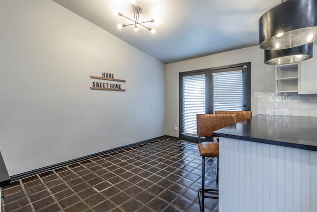 unfurnished dining area featuring an inviting chandelier and lofted ceiling