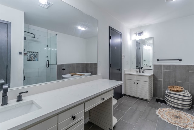 bathroom featuring vanity, tile walls, tile patterned flooring, and a shower with door