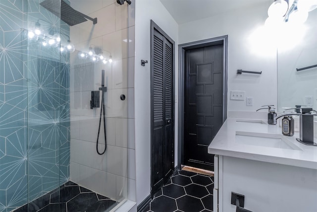 bathroom featuring vanity, a tile shower, and tile patterned flooring