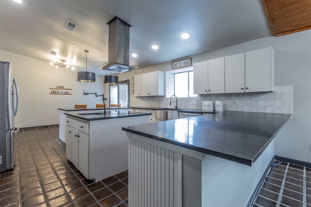 kitchen featuring stainless steel fridge, kitchen peninsula, white cabinets, and island range hood