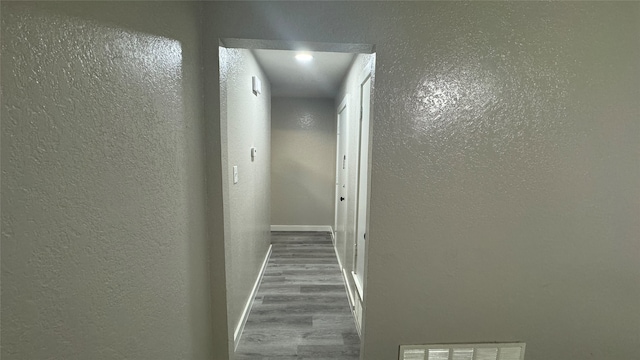 hallway with hardwood / wood-style floors