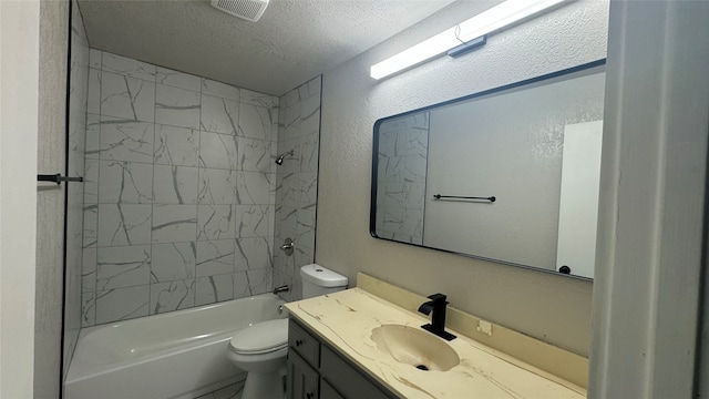 full bathroom featuring vanity, toilet, a textured ceiling, and tiled shower / bath