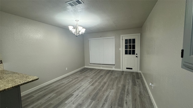 unfurnished dining area featuring a notable chandelier and hardwood / wood-style flooring