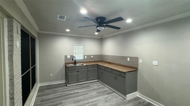 laundry room with ornamental molding, sink, light hardwood / wood-style floors, and ceiling fan