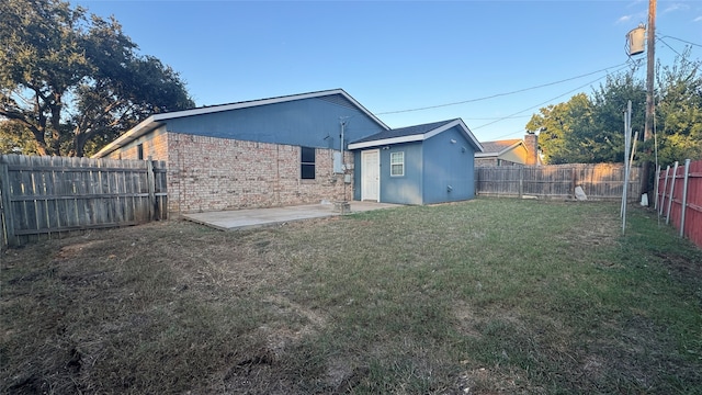 back of property featuring a storage shed, a yard, and a patio area