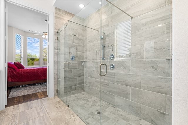 bathroom featuring ceiling fan, hardwood / wood-style flooring, and an enclosed shower