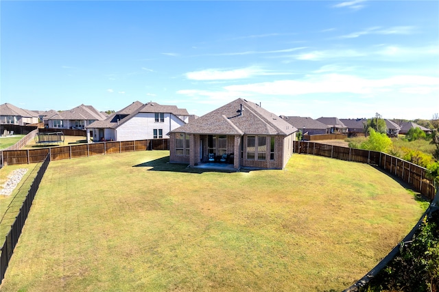 rear view of property featuring a yard and a patio area