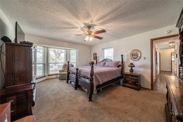 bedroom featuring light carpet, a textured ceiling, and ceiling fan