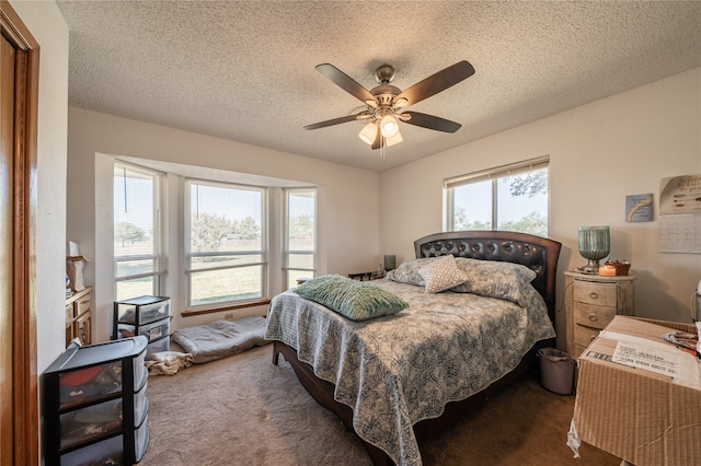 bedroom featuring ceiling fan, a textured ceiling, and dark colored carpet