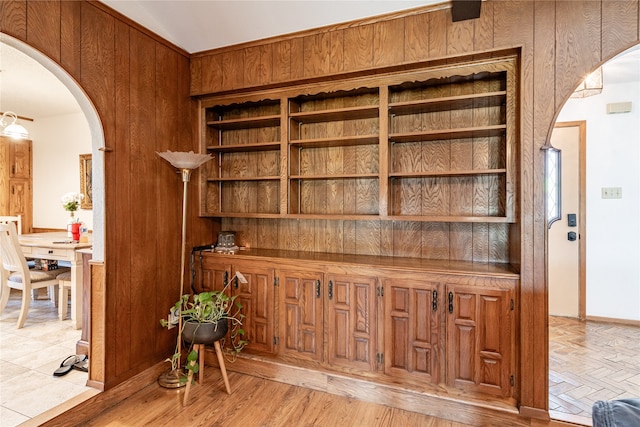 interior space with light hardwood / wood-style flooring and wooden walls