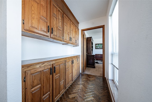 hall with dark parquet floors and a textured ceiling