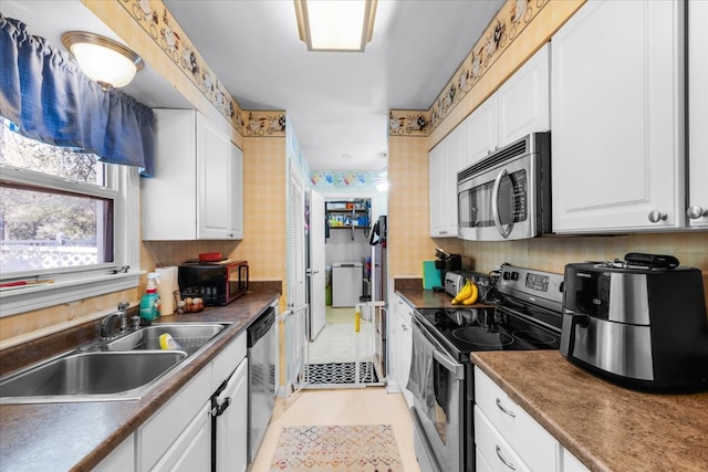 kitchen featuring light tile patterned floors, stainless steel appliances, sink, and white cabinets