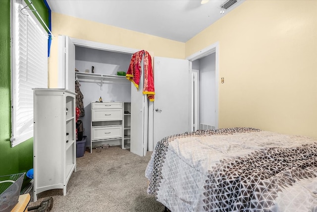 bedroom with a closet, ceiling fan, and light colored carpet