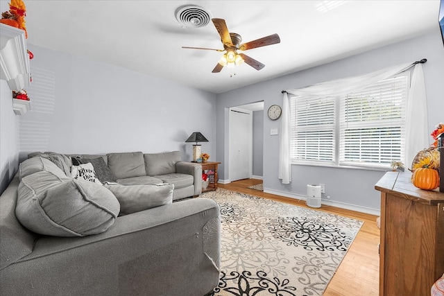 living room with light hardwood / wood-style floors and ceiling fan