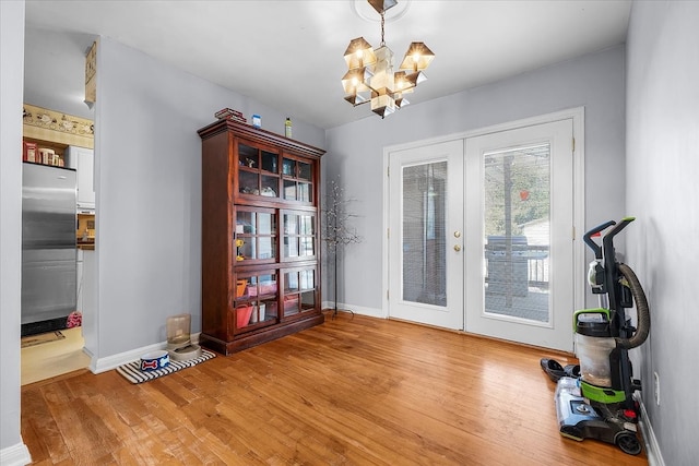 interior space with french doors, a notable chandelier, and wood-type flooring