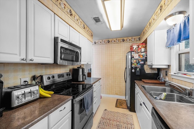 kitchen with light tile patterned flooring, white cabinetry, stainless steel appliances, and sink