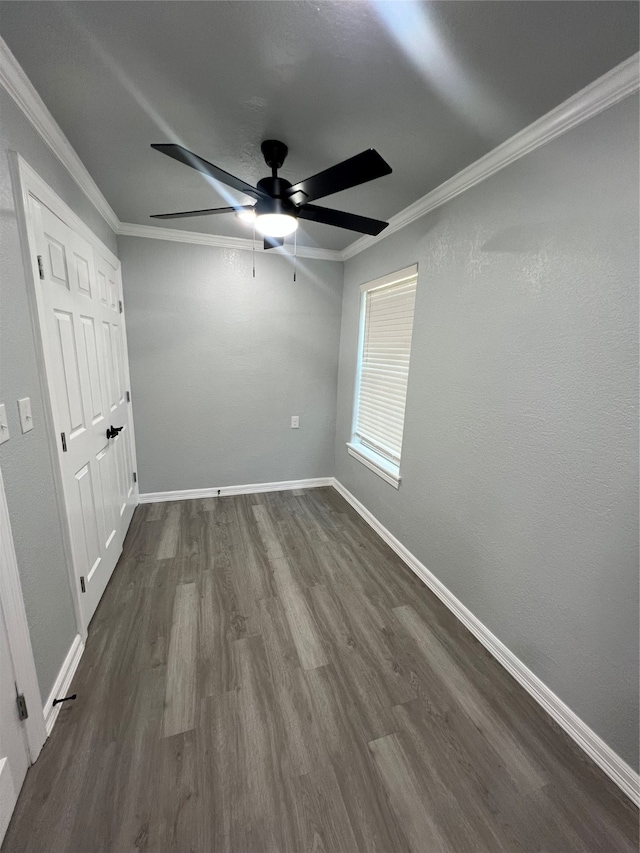 unfurnished bedroom featuring dark wood-type flooring, crown molding, and ceiling fan