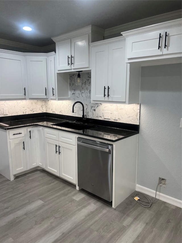 kitchen with dishwasher, white cabinets, light hardwood / wood-style floors, and tasteful backsplash