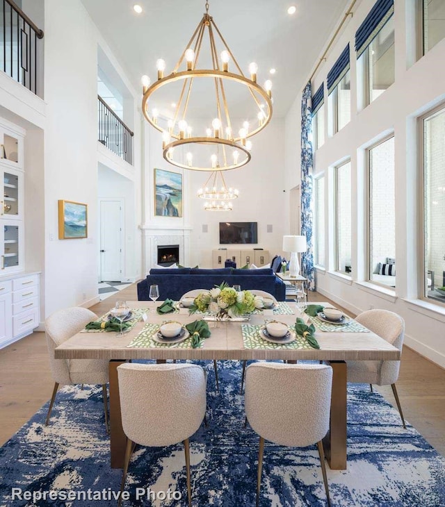 dining space featuring a chandelier, light hardwood / wood-style floors, and a high ceiling