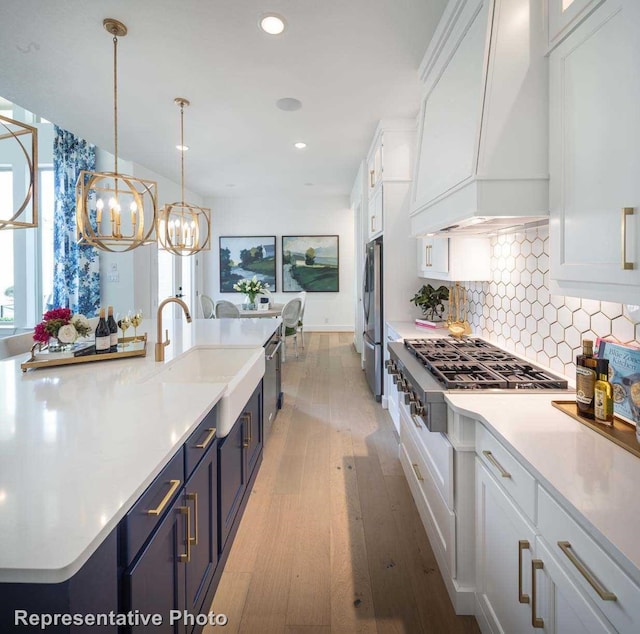 kitchen with custom range hood, light hardwood / wood-style floors, and white cabinetry