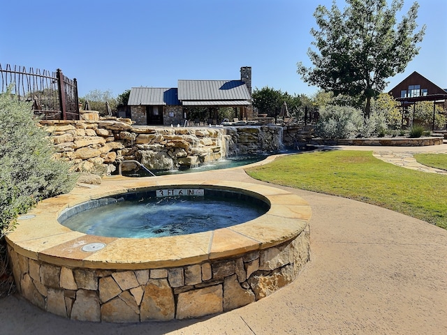 view of pool with an in ground hot tub and a yard