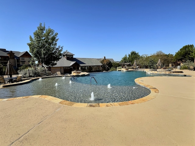 view of pool featuring pool water feature and a patio