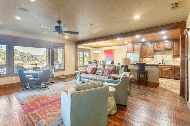 living room featuring beam ceiling, sink, a textured ceiling, ceiling fan with notable chandelier, and dark hardwood / wood-style flooring