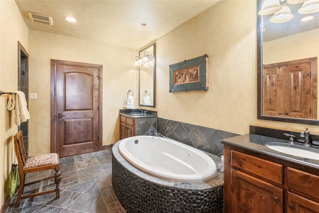 bathroom with vanity and tiled bath