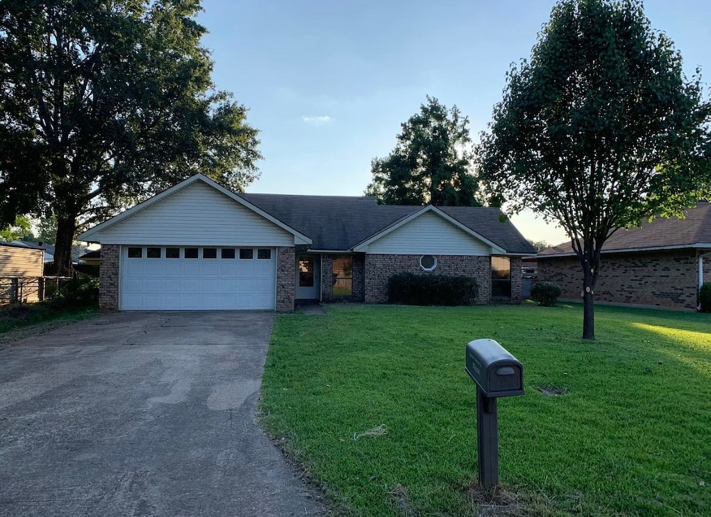 ranch-style home with a front yard and a garage