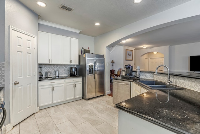 kitchen with white cabinets, decorative backsplash, sink, and appliances with stainless steel finishes