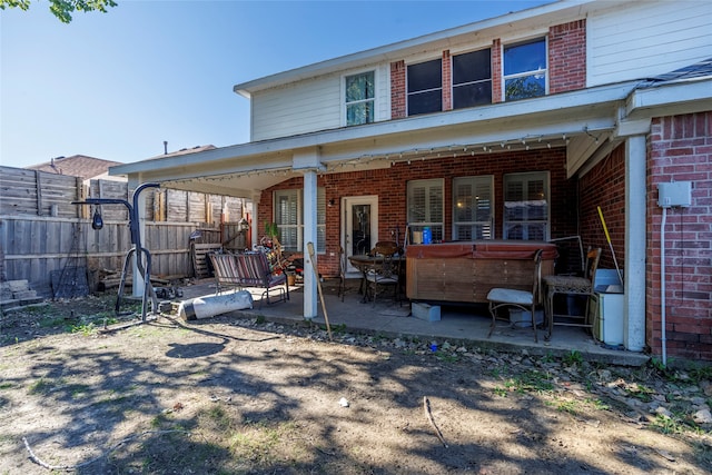 rear view of house featuring a patio area and a hot tub