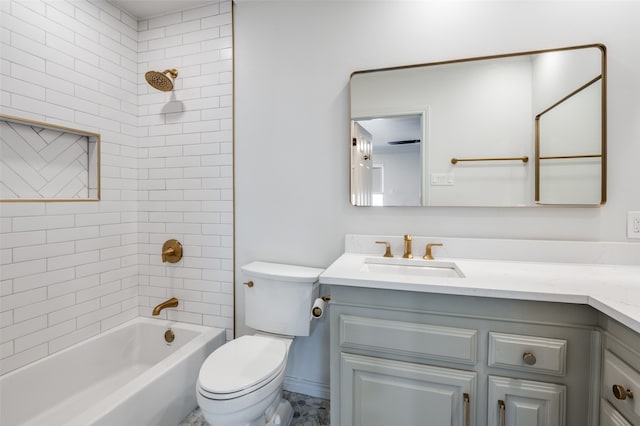 full bathroom featuring tiled shower / bath, vanity, and toilet