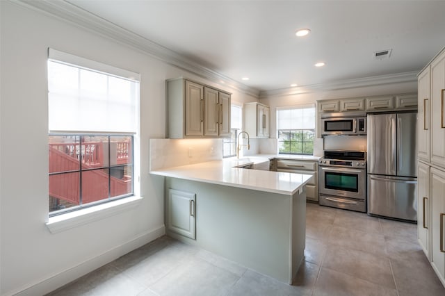 kitchen featuring kitchen peninsula, ornamental molding, sink, light tile patterned floors, and appliances with stainless steel finishes